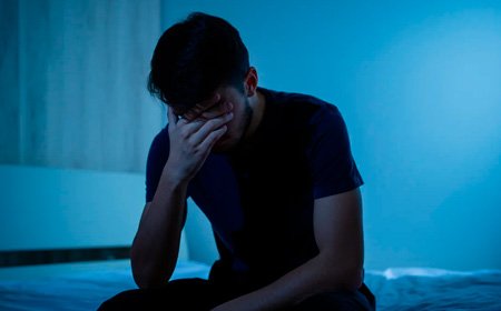 Мужчина сидит на кровати