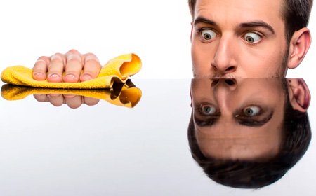 Парень натирает поверхность стола